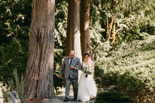 Bride walking down the aisle in the woods at Snohomish Wedding Venue The Lookout Lodge